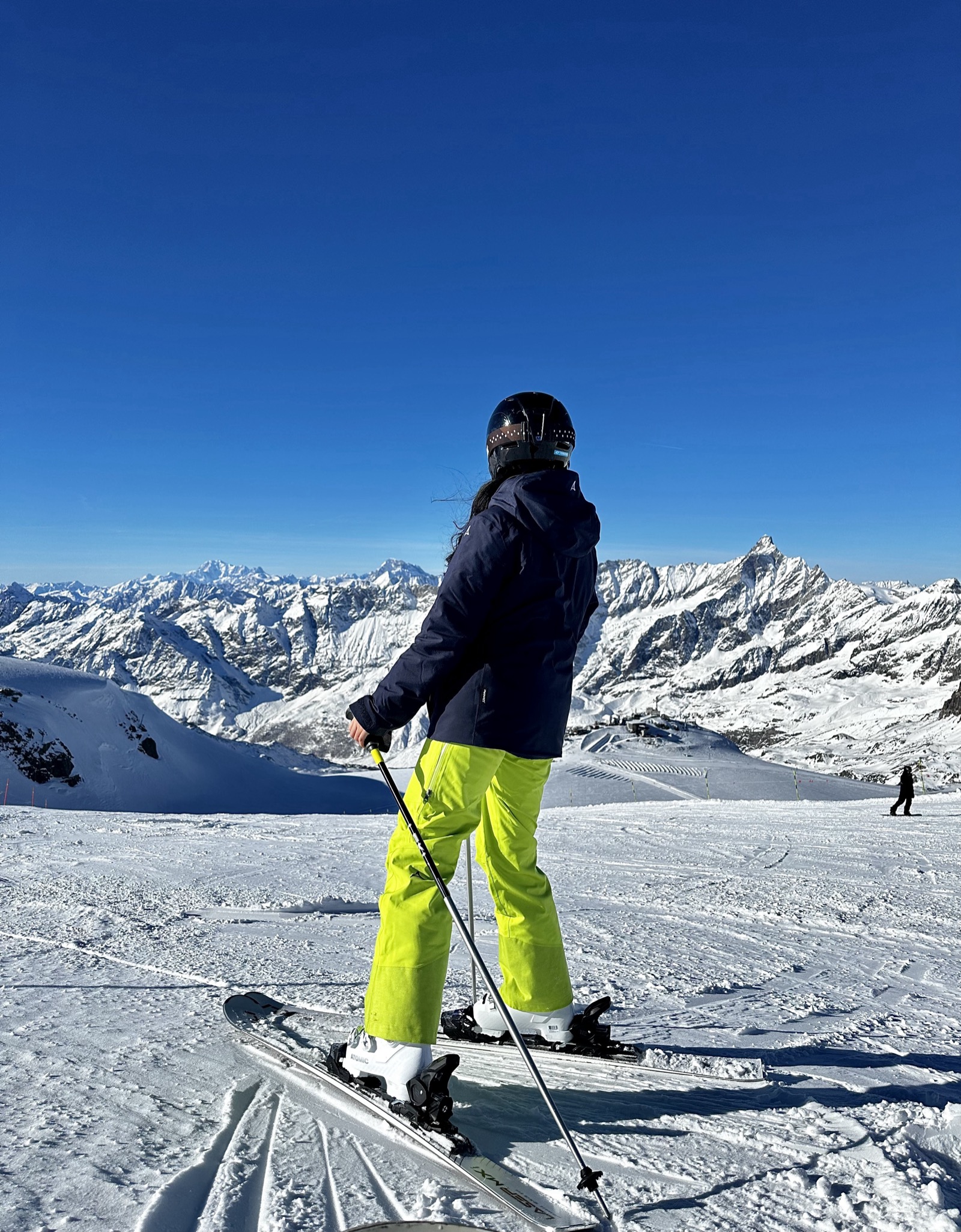 Joyce skiing by the Matterhorn in a navy jacket and neon pants